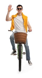 Smiling man in sunglasses riding bicycle with basket on white background