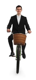 Smiling man riding bicycle with basket on white background