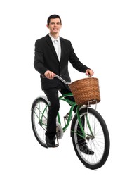 Smiling man riding bicycle with basket on white background