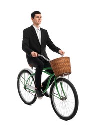 Smiling man riding bicycle with basket on white background