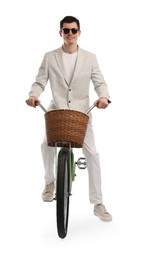 Photo of Smiling man in sunglasses riding bicycle with basket on white background