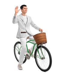 Smiling man on bicycle with basket against white background