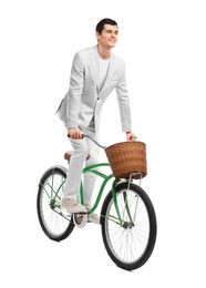 Photo of Smiling man riding bicycle with basket on white background