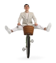 Photo of Smiling man having fun while riding bicycle with basket on white background