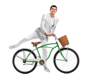 Smiling man riding bicycle with basket on white background