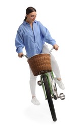 Beautiful young woman on bicycle with basket against white background