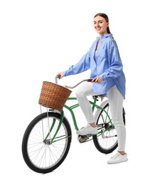 Smiling woman on bicycle with basket against white background