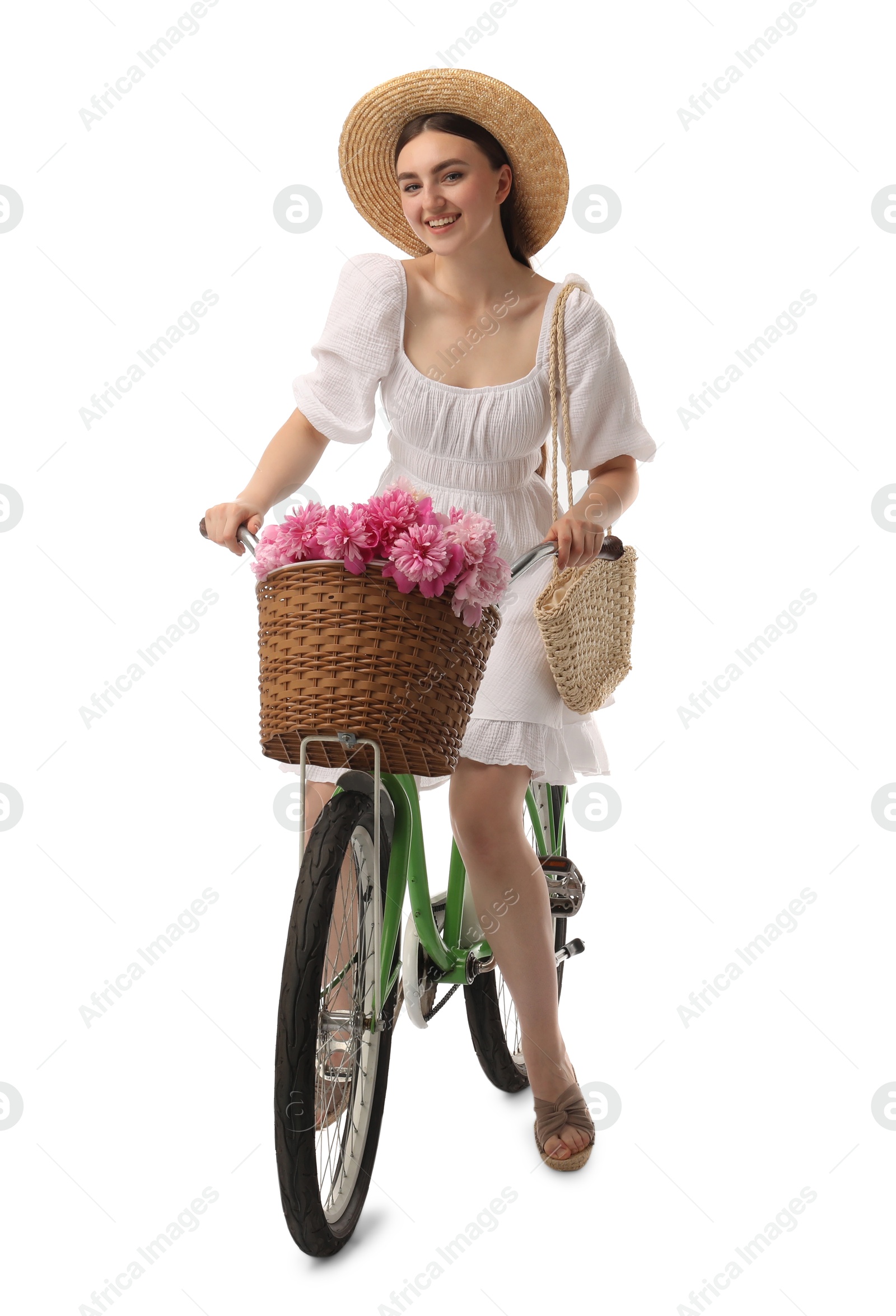 Photo of Smiling woman riding bicycle with basket of peony flowers on white background