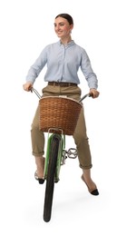 Smiling woman riding bicycle with basket on white background