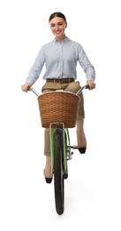 Smiling woman riding bicycle with basket on white background