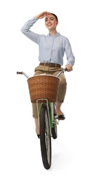 Smiling woman riding bicycle with basket on white background