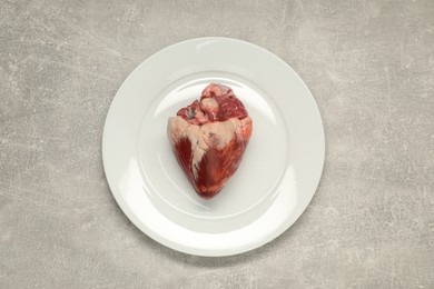 Raw heart on grey table, top view