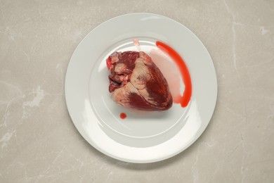 Photo of Raw heart on light grey marble table, top view