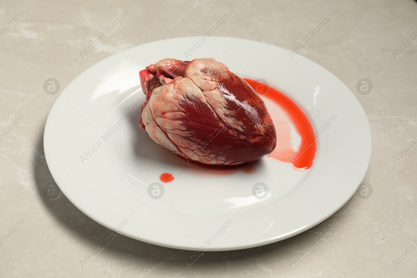 Photo of Raw heart on light grey marble table