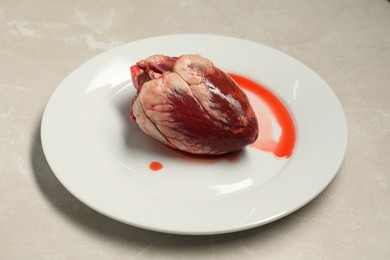 Raw heart on light grey marble table