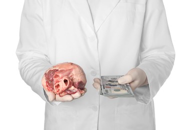 Photo of Doctor with heart and dollar banknotes on white background, closeup