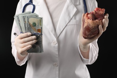 Photo of Doctor with heart and dollar banknotes on black background, closeup