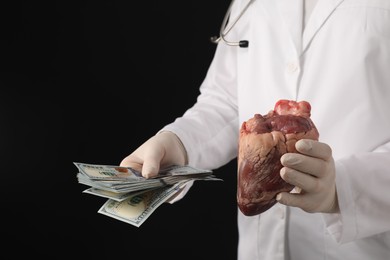 Photo of Doctor with heart and dollar banknotes on black background, closeup