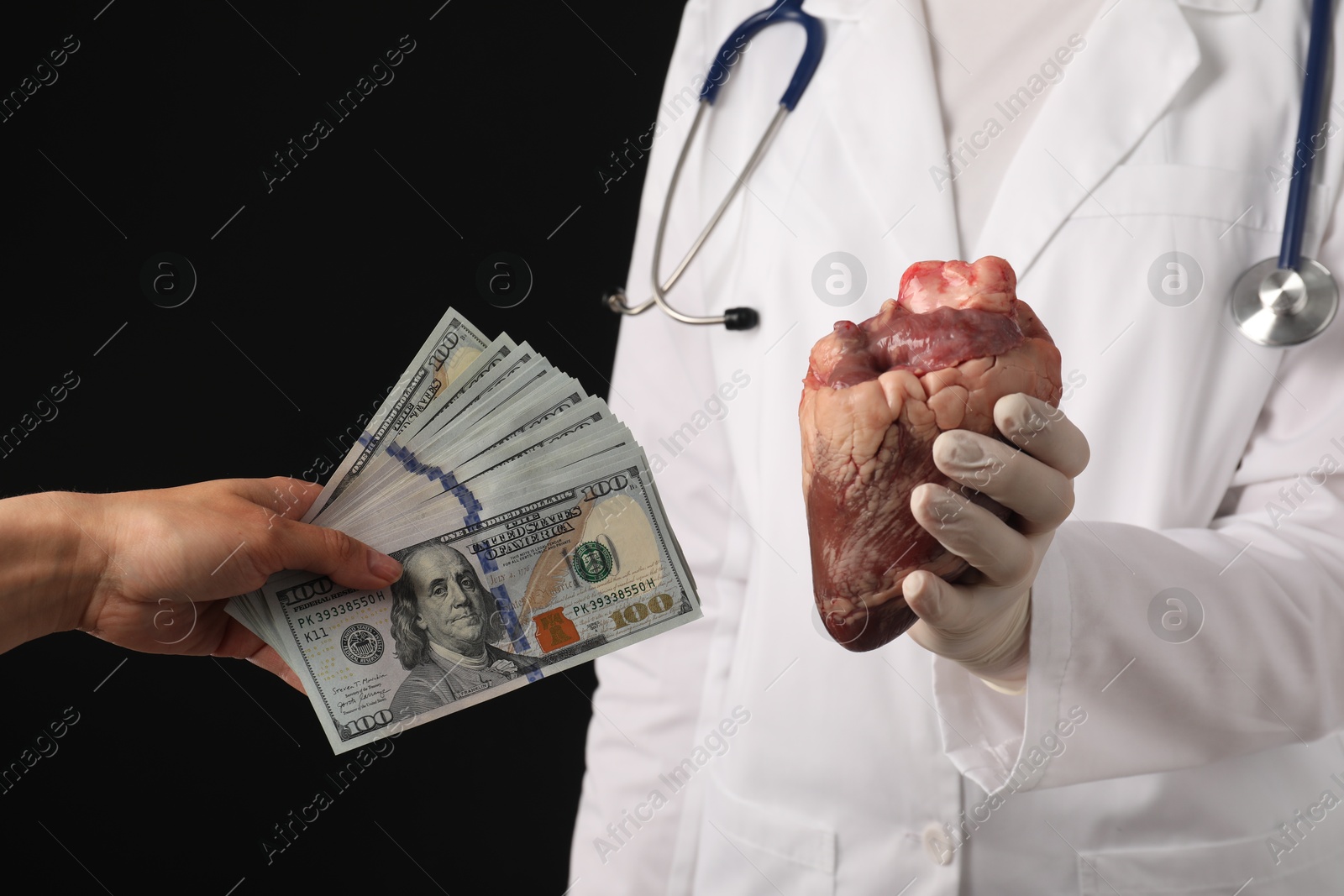 Photo of Patient giving dollar banknotes to doctor with heart on black background, closeup