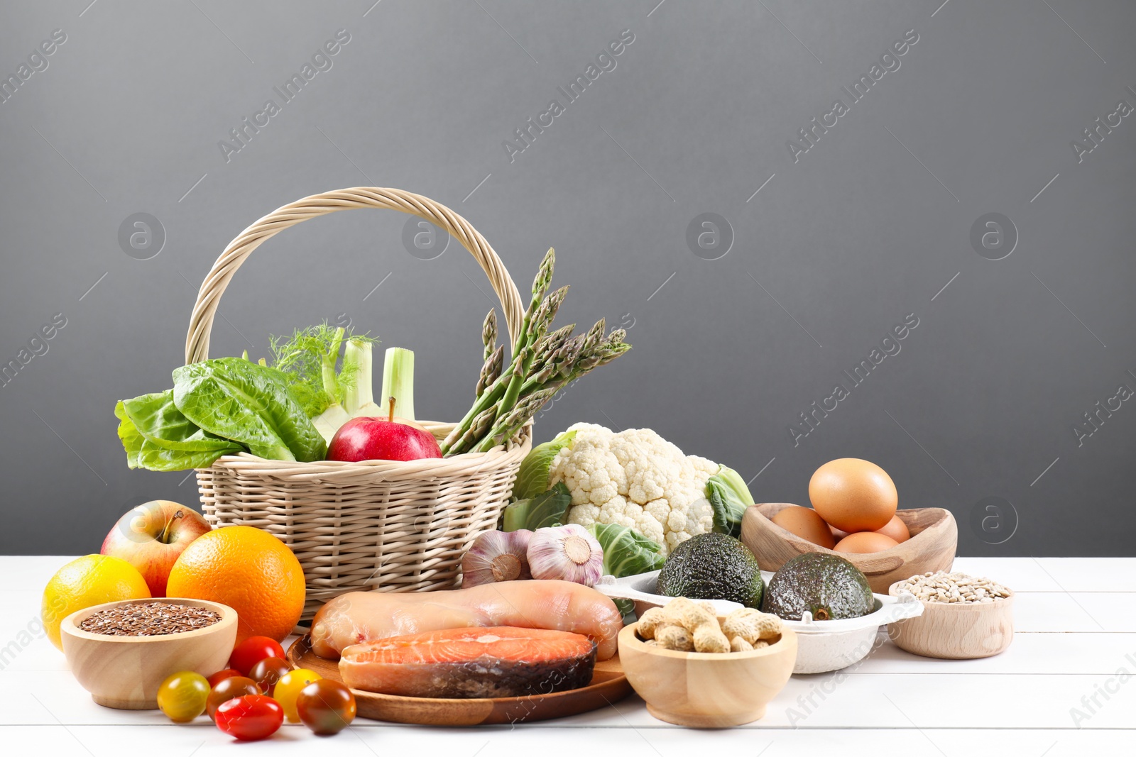 Photo of Healthy food. Basket with different fresh products on white wooden table