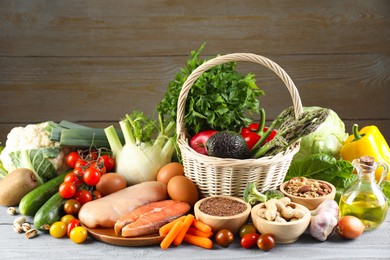 Photo of Healthy food. Basket with different fresh products on grey wooden table