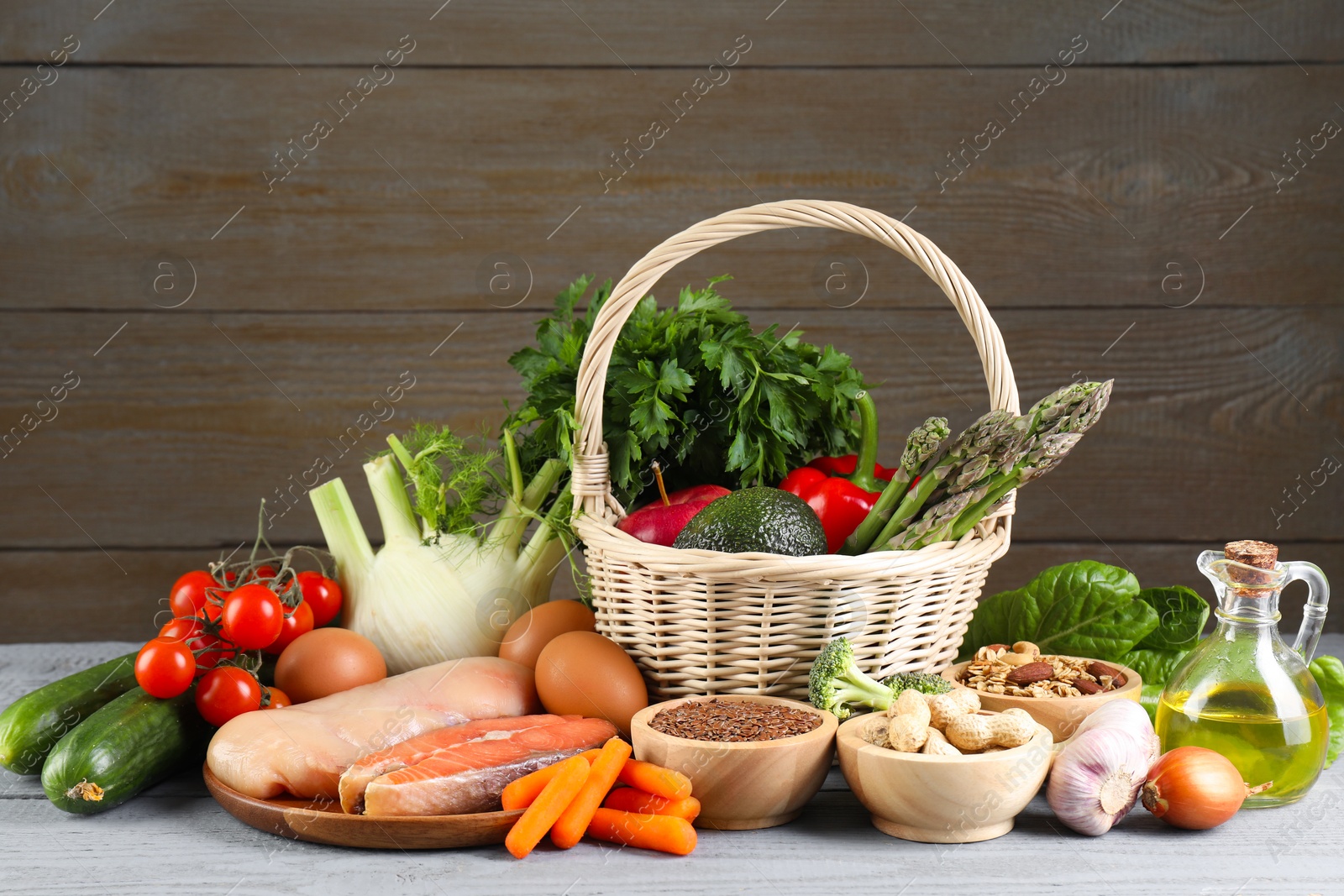 Photo of Healthy food. Basket with different fresh products on grey wooden table