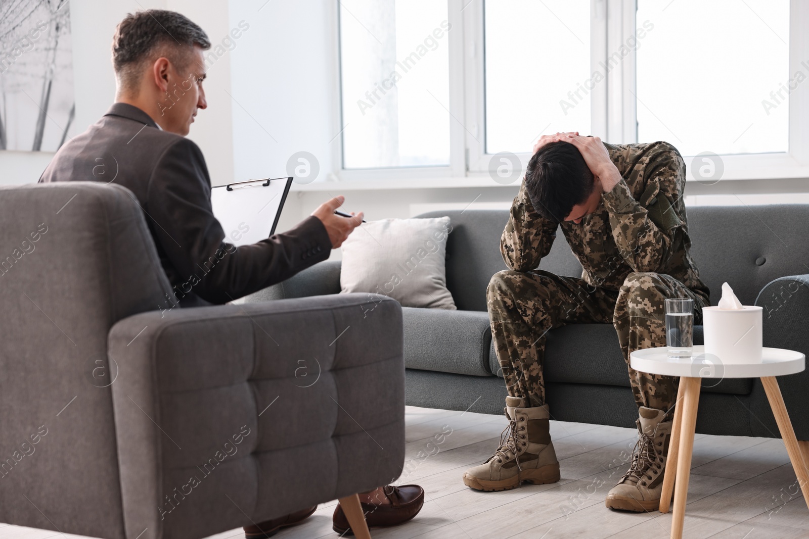 Photo of Professional psychotherapist working with military man in office