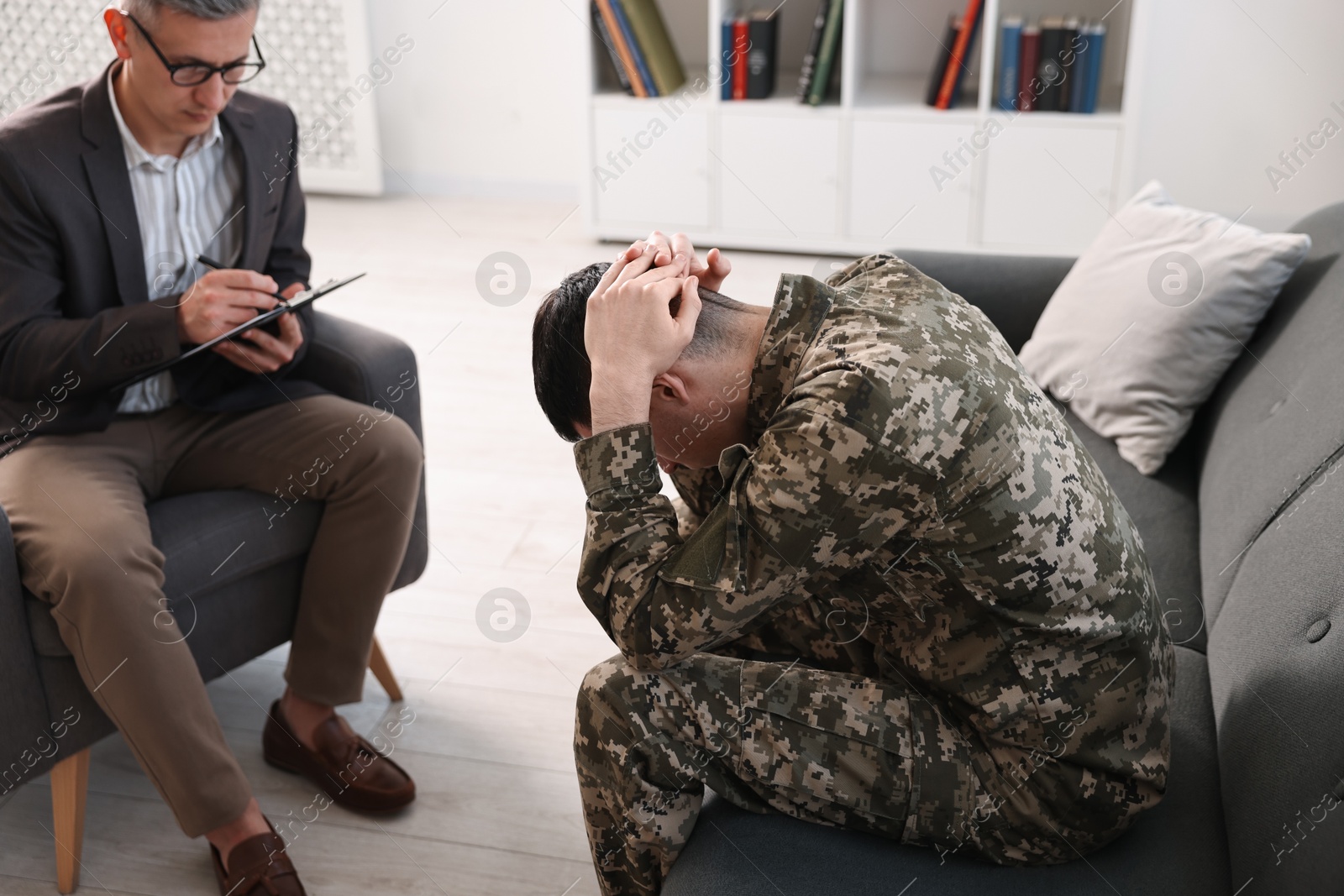 Photo of Professional psychotherapist working with military man in office