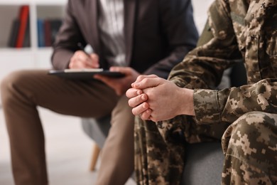 Photo of Professional psychotherapist working with military man in office, closeup