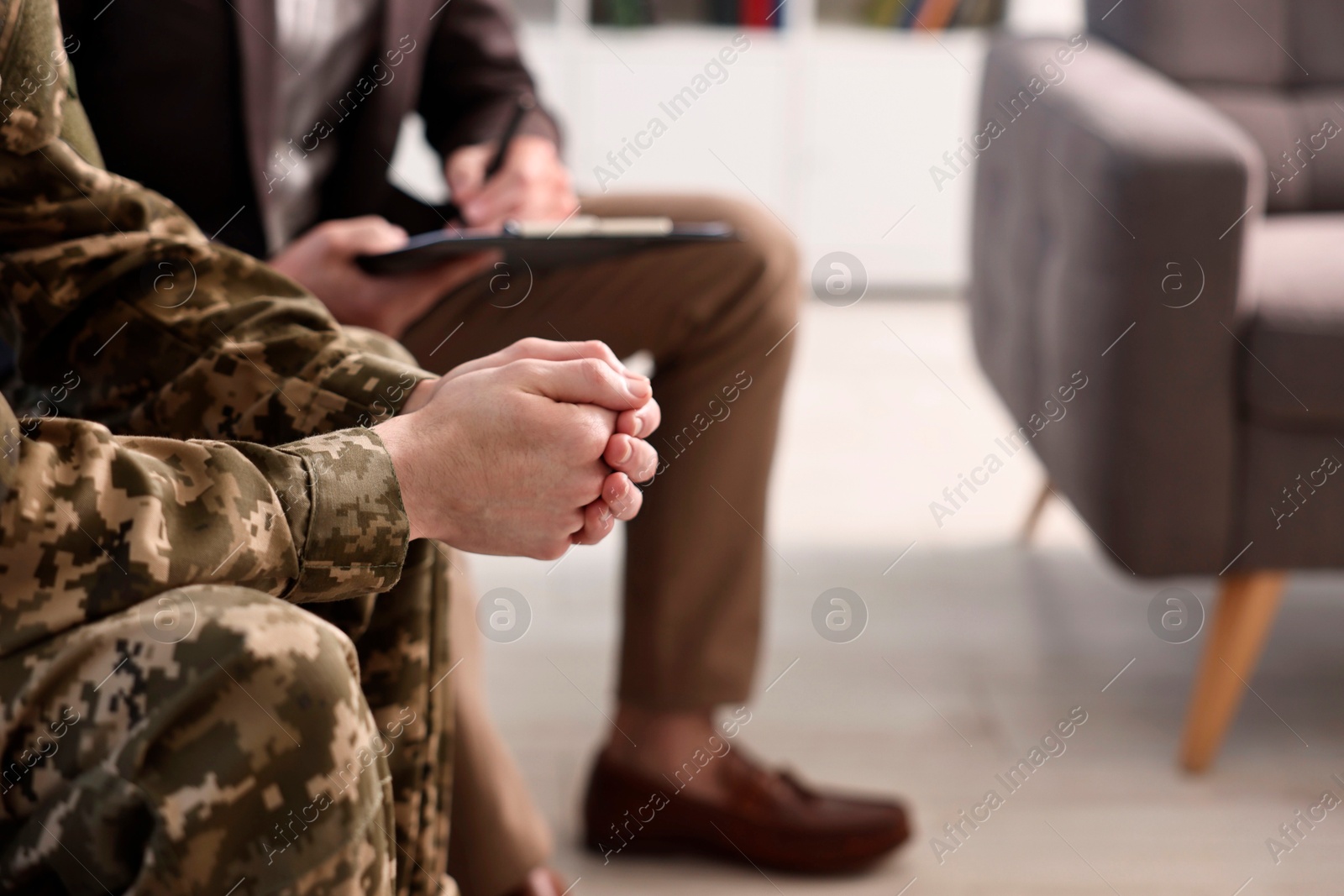 Photo of Professional psychotherapist working with military man in office, closeup