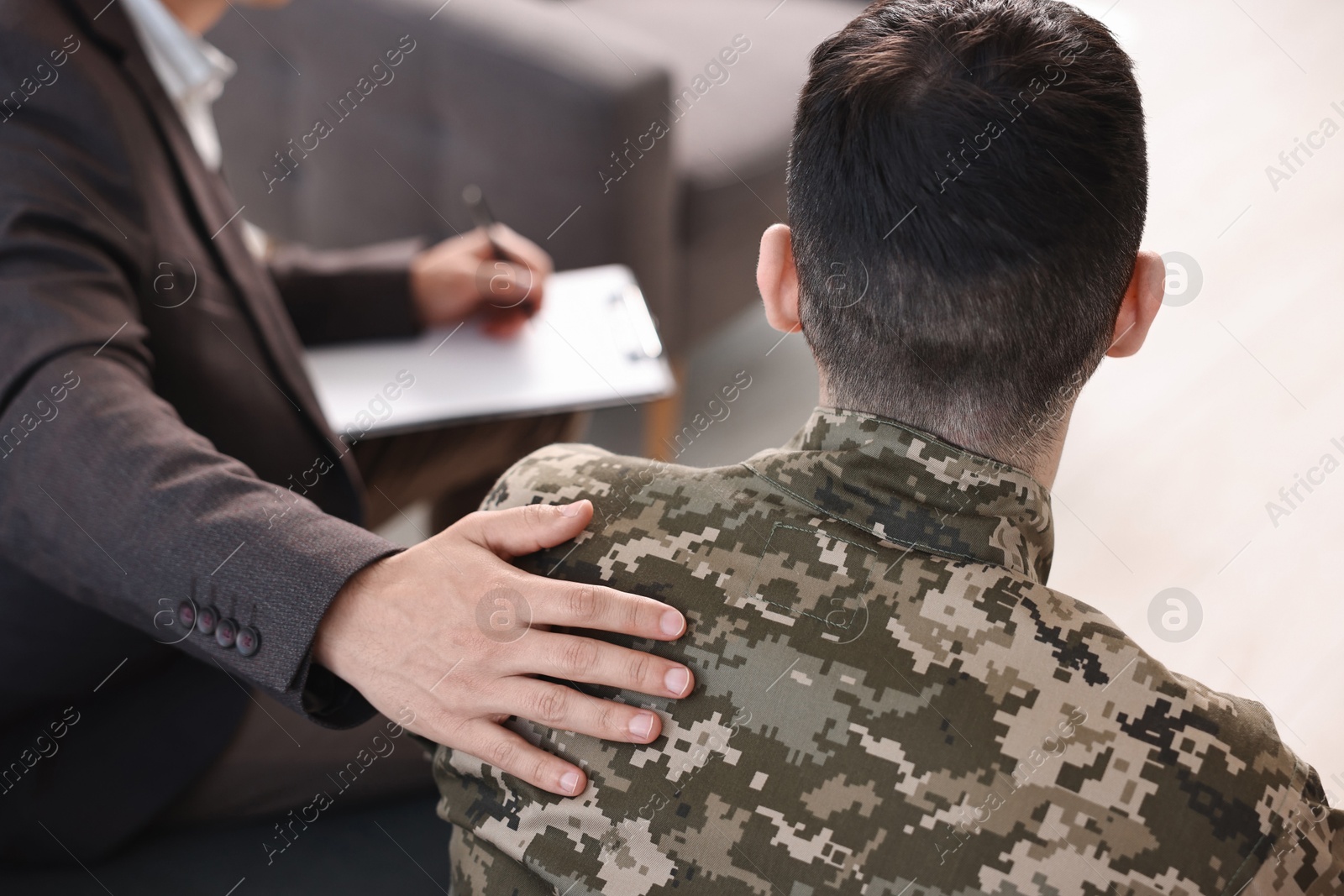 Photo of Professional psychotherapist working with military man in office, closeup