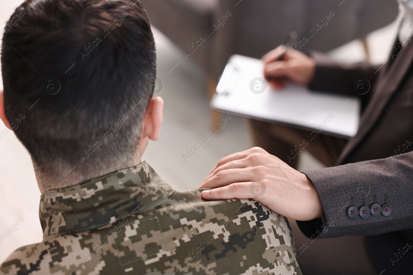 Photo of Professional psychotherapist working with military man in office, closeup