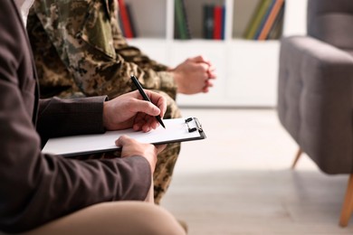 Professional psychotherapist working with military man in office, closeup