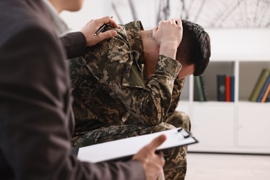 Photo of Professional psychotherapist working with military man in office, closeup