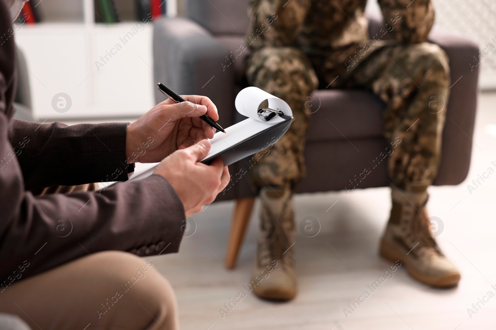 Photo of Professional psychotherapist working with military man in office, closeup