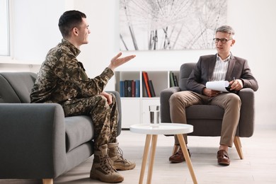 Professional psychotherapist working with military man in office