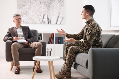 Professional psychotherapist working with military man in office