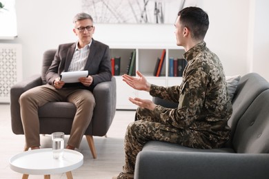 Photo of Professional psychotherapist working with military man in office