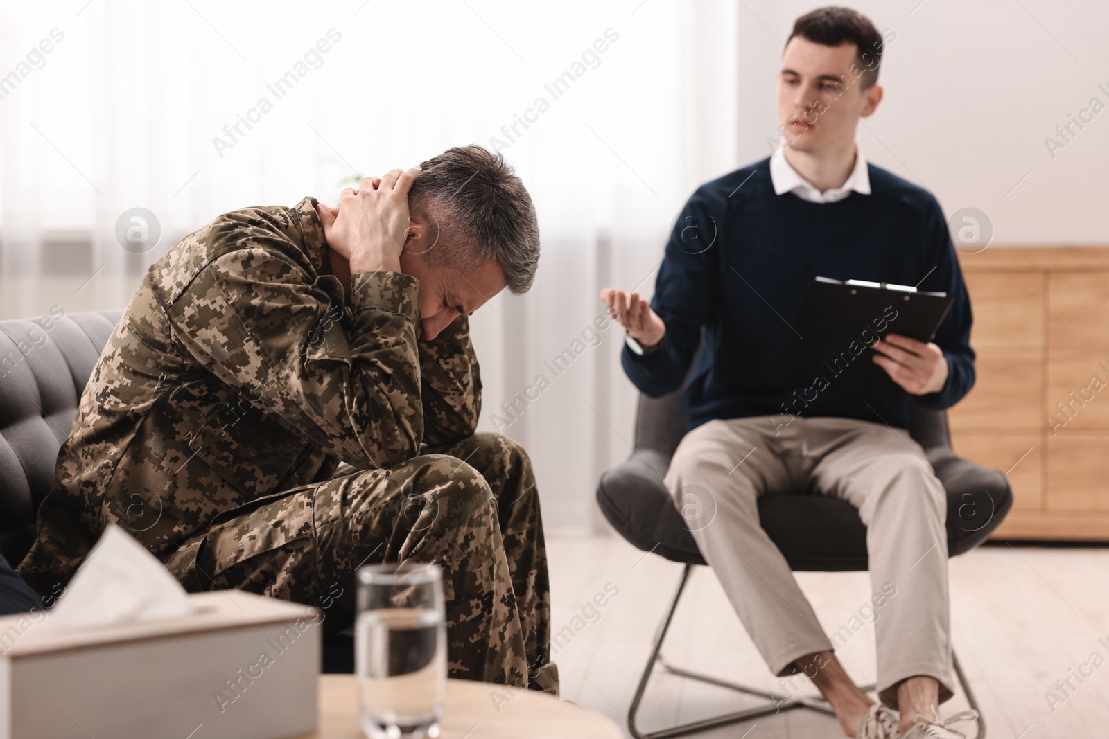 Photo of Professional psychotherapist working with military man in office