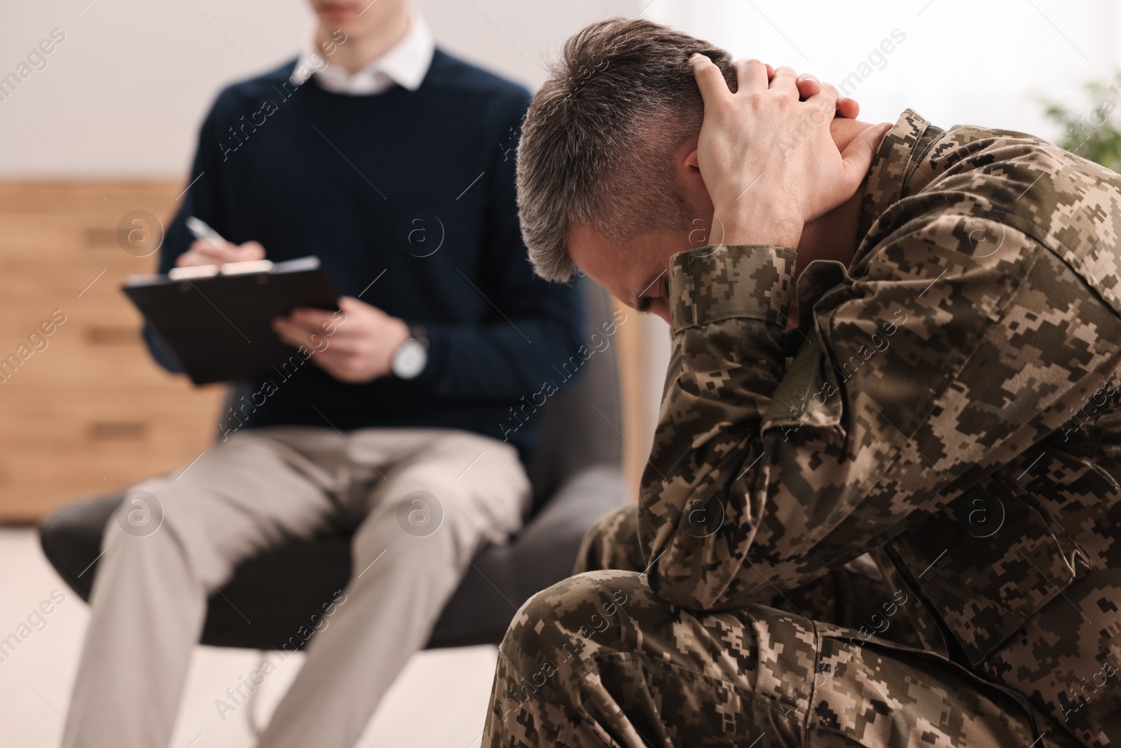 Photo of Professional psychotherapist working with military man in office