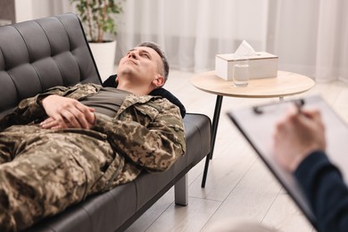 Photo of Professional psychotherapist working with military man in office