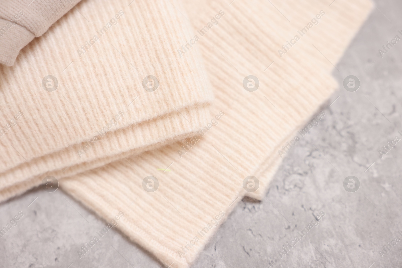 Photo of Soft folded sweater on grey table, above view