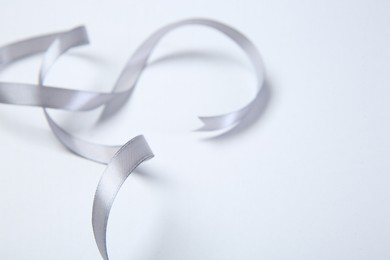 Photo of One beautiful grey ribbon on white background, space for text