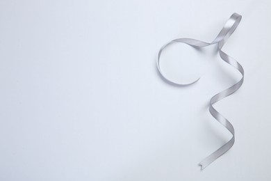 Photo of One beautiful grey ribbon on white background, top view. Space for text