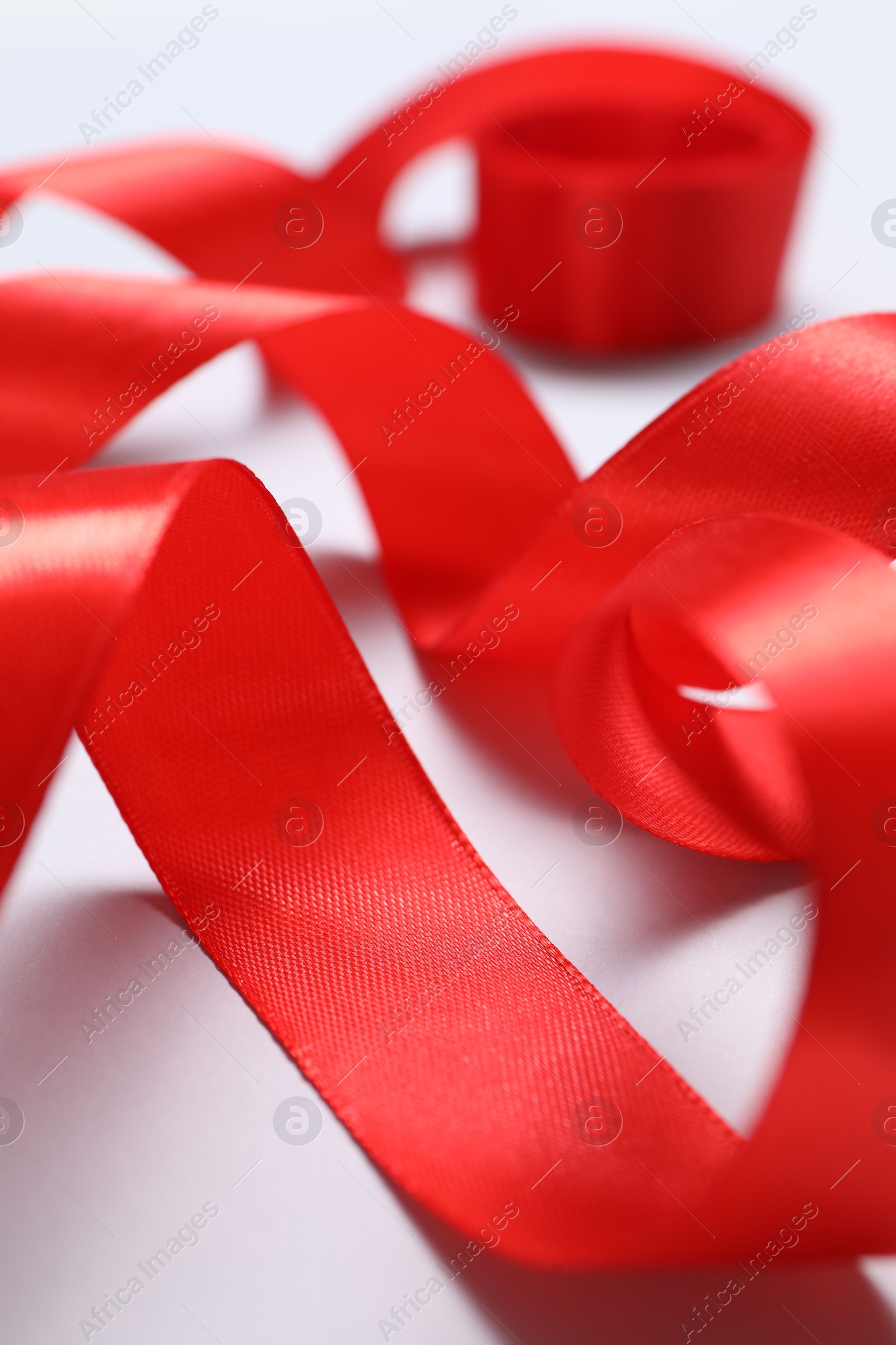 Photo of One beautiful red ribbon on white background, closeup