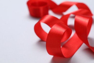 One beautiful red ribbon on white background, closeup. Space for text