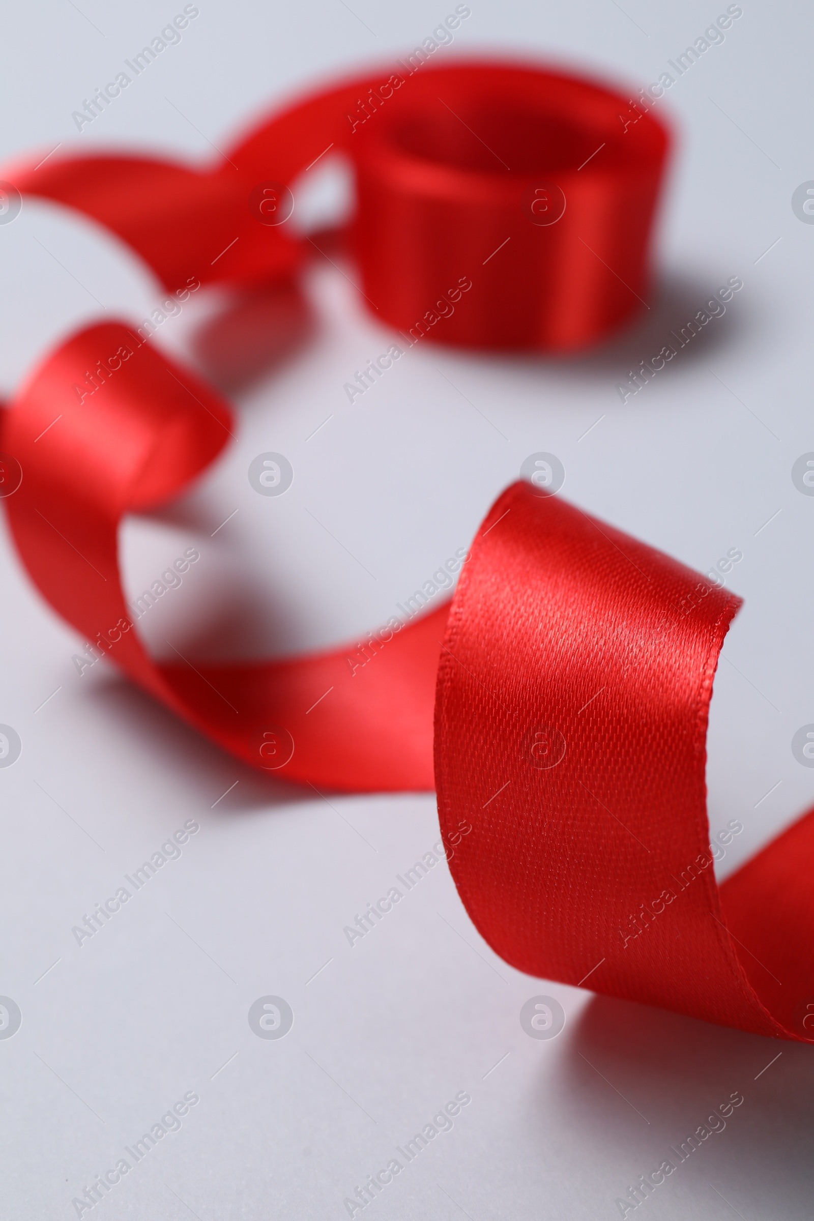 Photo of One beautiful red ribbon on white background, closeup