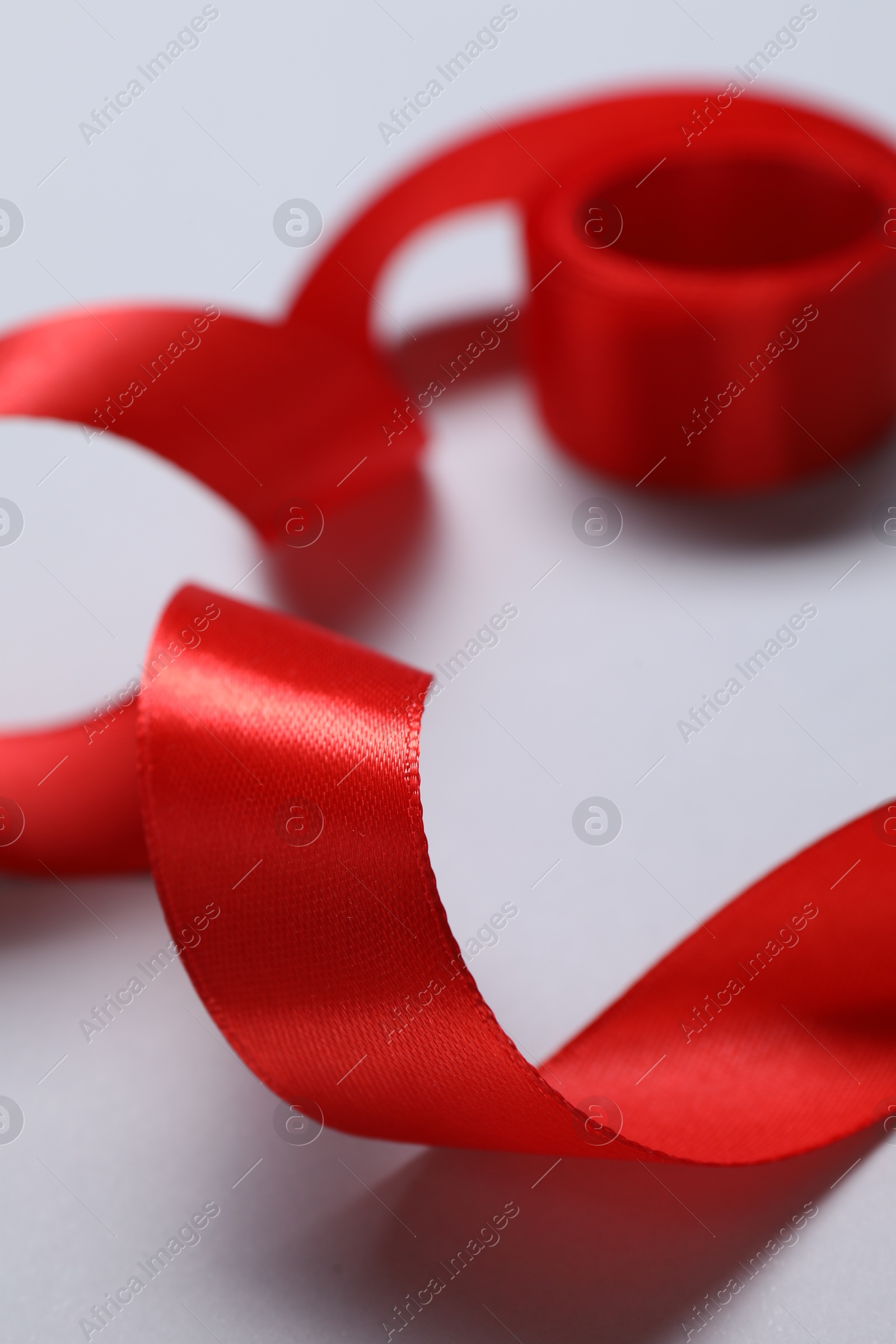 Photo of One beautiful red ribbon on white background, closeup