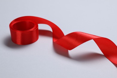 Photo of One beautiful red ribbon on white background, closeup