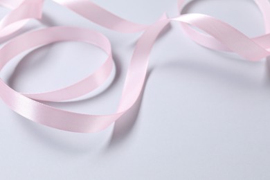 Photo of One beautiful pink ribbon on white background, space for text